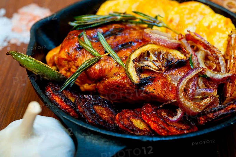 Roasted grilled BBQ chicken breast with herbs and spices rustic style on iron skillet