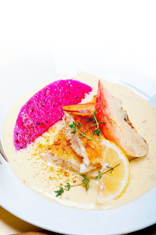 Sea bream orata fillet butter pan fried with fresh peach prune and dragonfruit slices thyme on top