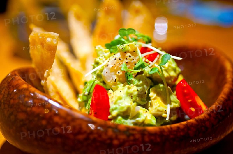 Fresh avocado and shrimps salad with nachos on side