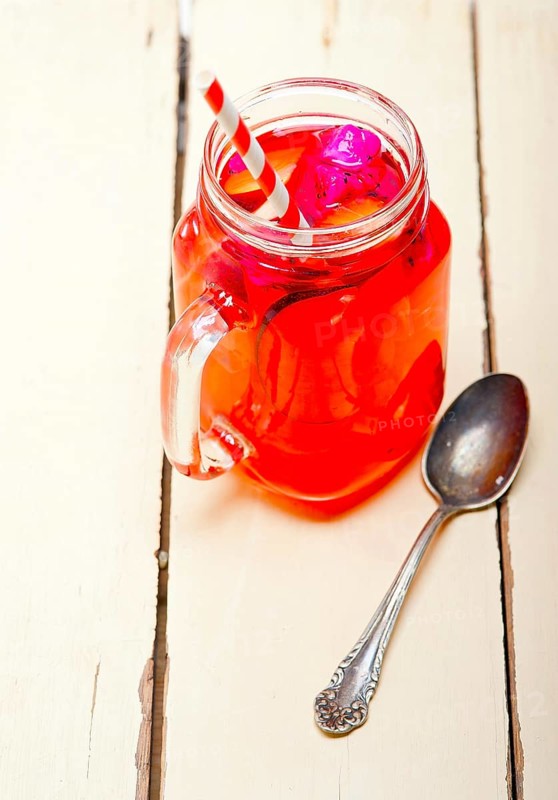 Fresh fruit punch refreshing summer drink over white rustic wood table