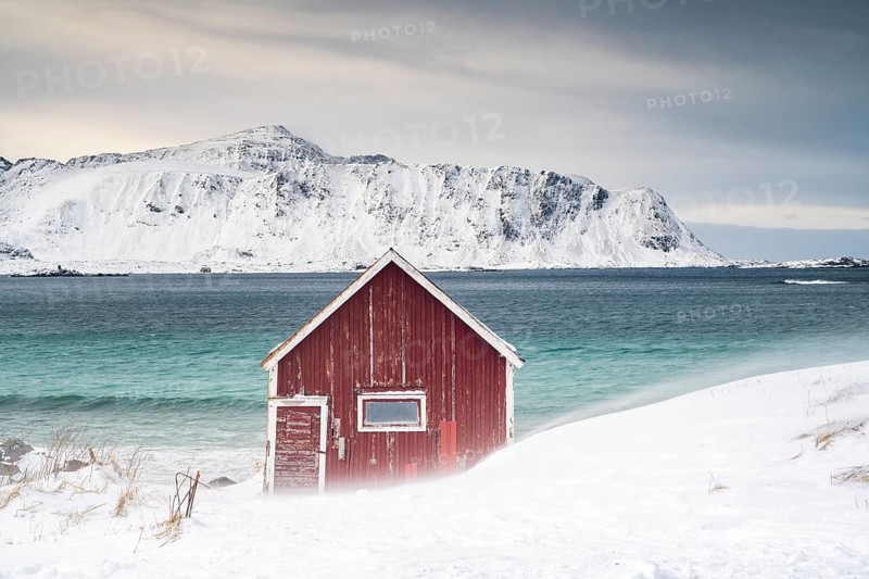 Red Rorbuer fishing hut on the beach in the snow