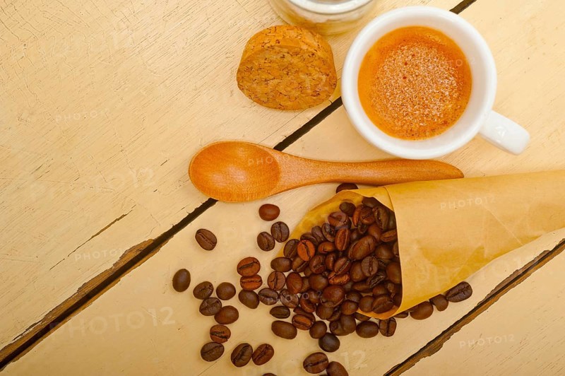 Espresso coffee and beans on a paper cone cornucopia over white background