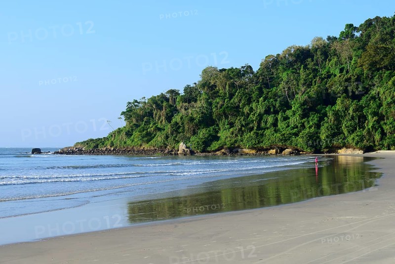 Little girl with sand bucket on lonely beach