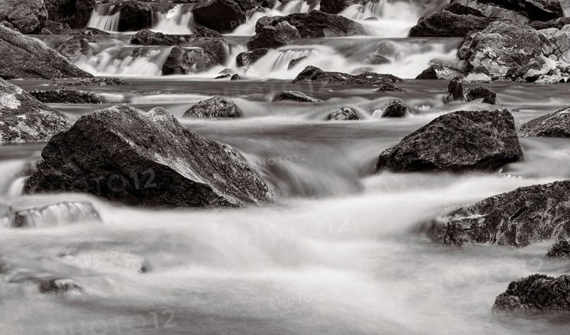 Mountain stream flows over moss-covered stones