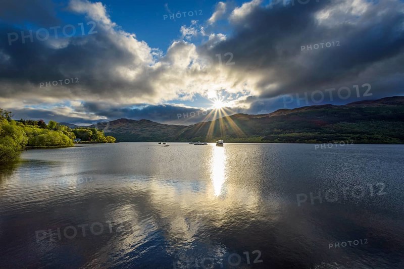 Lake with dramatic clouds and sun in spring