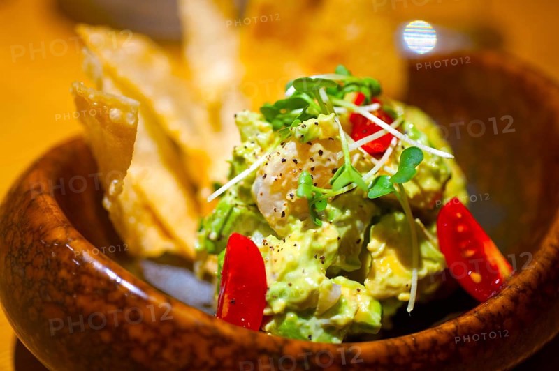Fresh avocado and shrimps salad with nachos on side