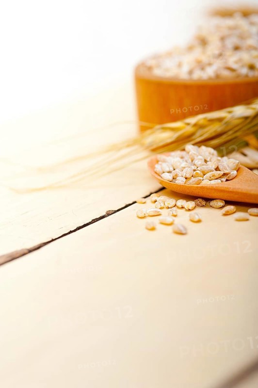 Organic wheat grains over rustic wood table macro closeup
