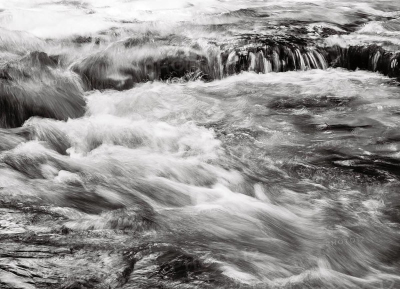 Mountain stream flows over moss-covered stones
