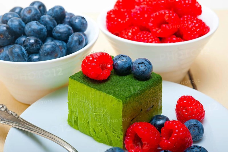 Green tea matcha mousse cake with raspberries and blueberries on top