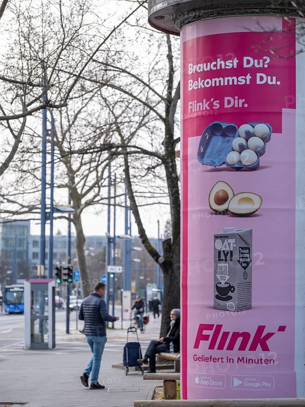 Advertisement of the delivery service Flink on an advertising pillar