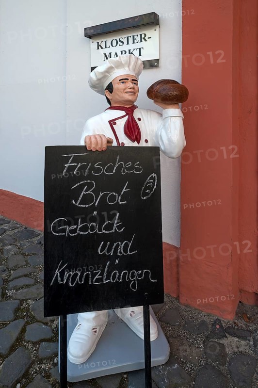 Baker's figure with offer board in front of the convent shop