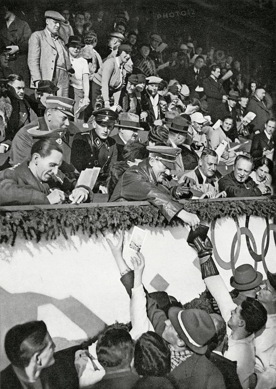 Reich Chancellor Adolf Hitler signs autographs for Canadian athletes in the Artificial Ice Stadium