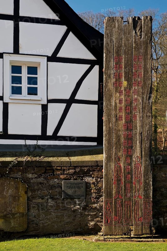 Wooden stele made of ship planks in front of half-timbered house at St. Pancratius Church on the occasion of the 1000th anniversary of the parish