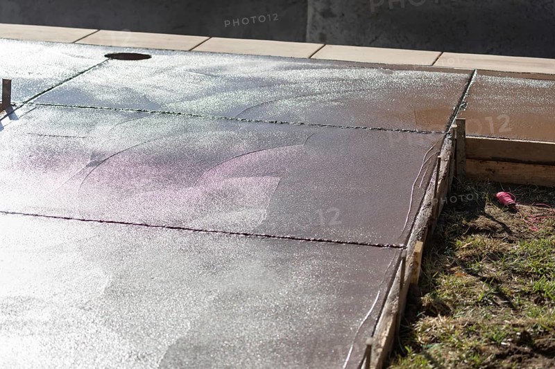 Freshly poured deck cement curing in wood frame