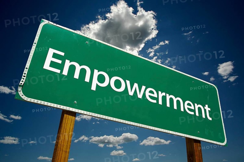 Empowerment green road sign over dramatic clouds and sky