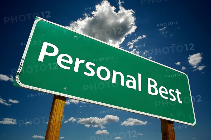 Personal best green road sign over dramatic blue sky and clouds with clipping path
