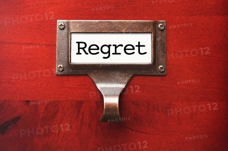 Lustrous wooden cabinet with regret file label in dramatic light