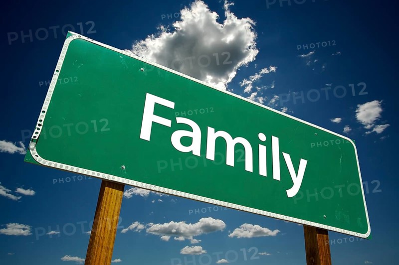Family road sign with dramatic clouds and sky