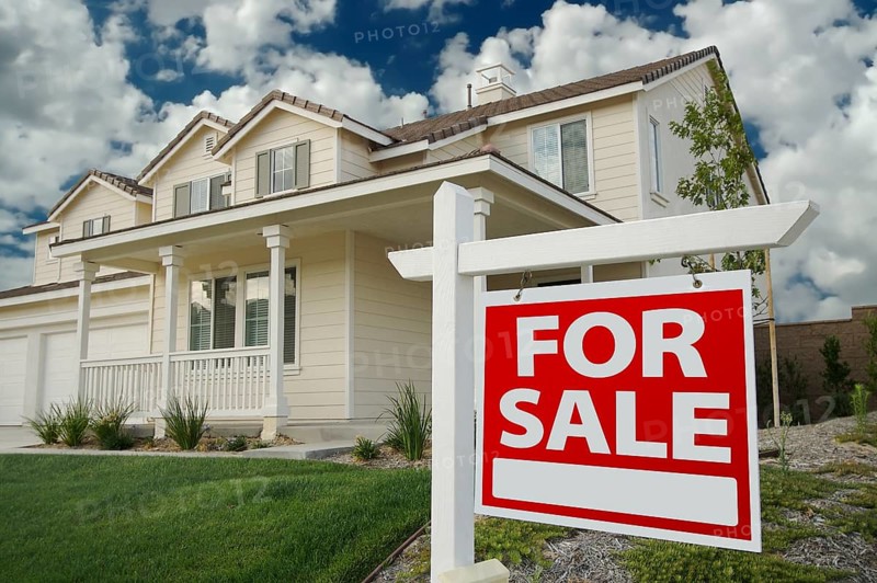 Home for sale sign in front of beautiful new home