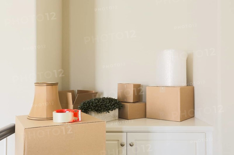 Variety of packed moving boxes and materials in empty room