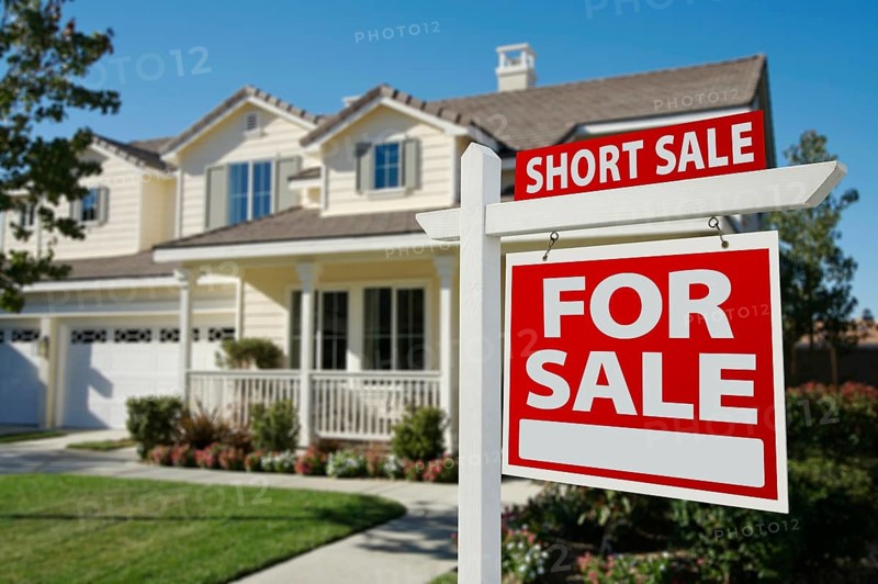 Short sale home for sale real estate sign and house