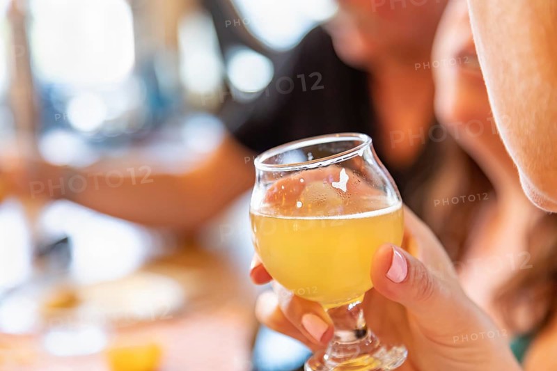 Female hand holding glass of micro brew beer at bar