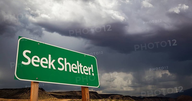 Seek shelter green road sign with dramatic clouds and rain
