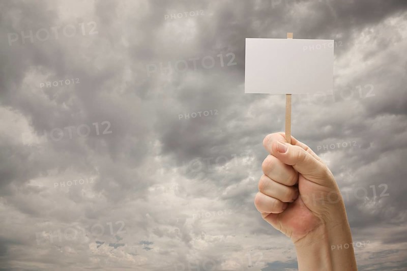Man holding blank sign over dramatic storm cloudy sky