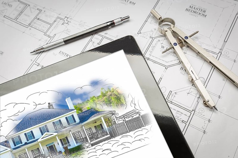 Computer tablet showing house illustration sitting on house plans with pencil and compass