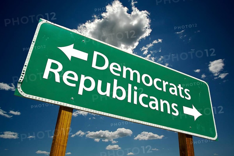 Democrats and republicans green road sign over dramatic blue sky and clouds with clipping path