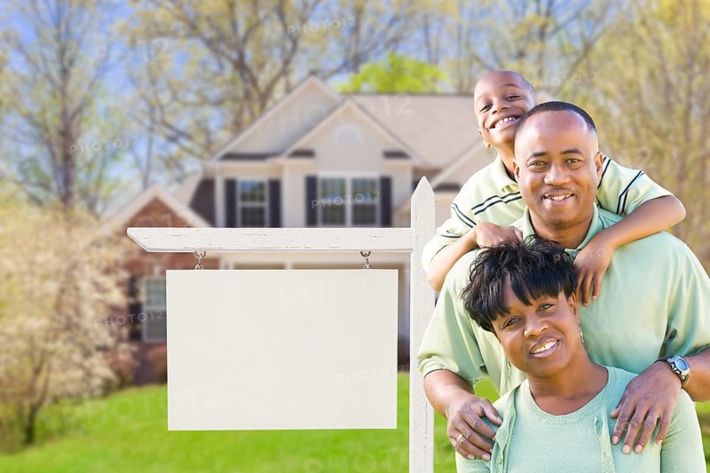 African american family in front of blank real estate sign and new house