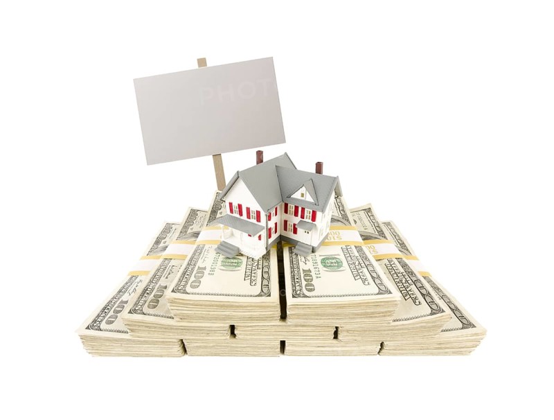 Small house on stacks of hundred dollar bills and blank sign isolated on a white background