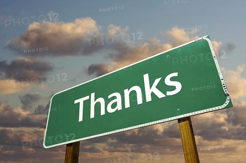 Thanks green road sign over dramatic clouds and sky