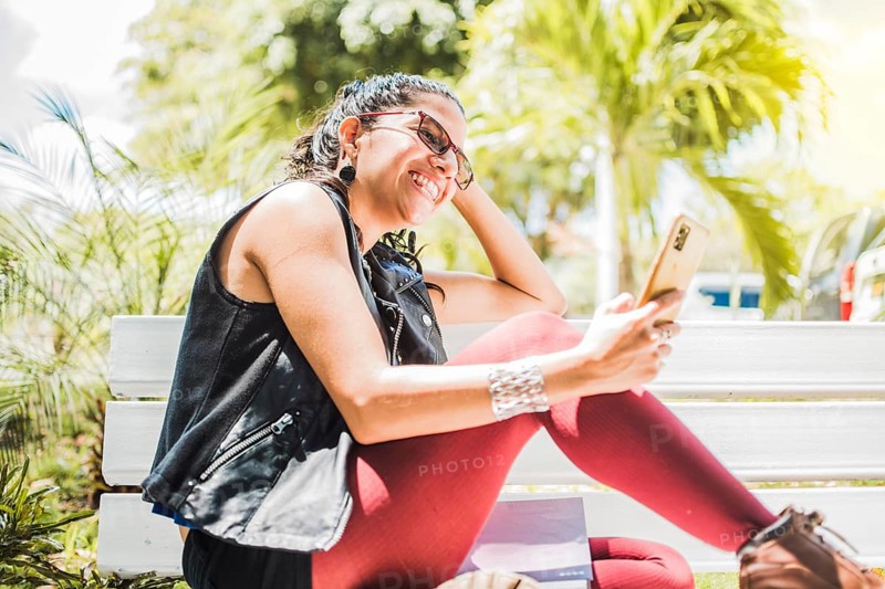 Girl sitting on a bench checking her cell phone