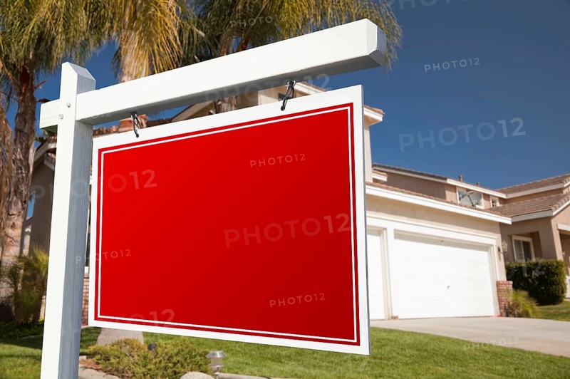 Blank real estate sign in front of house