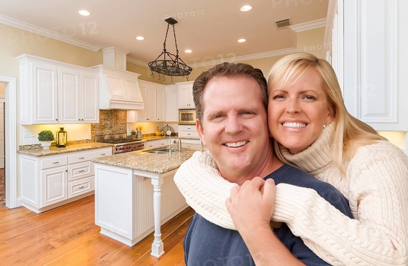 Happy couple hugging inside beautiful custom kitchen