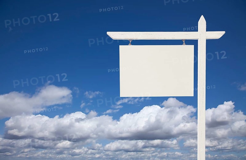 Blank white real estate sign over clouds and sky ready for your own message
