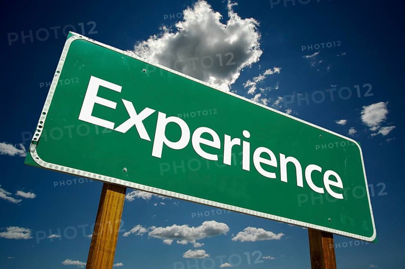 Experience road sign with dramatic clouds and sky