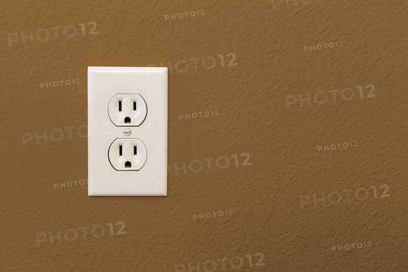 Electrical sockets in colorful brown wall of house