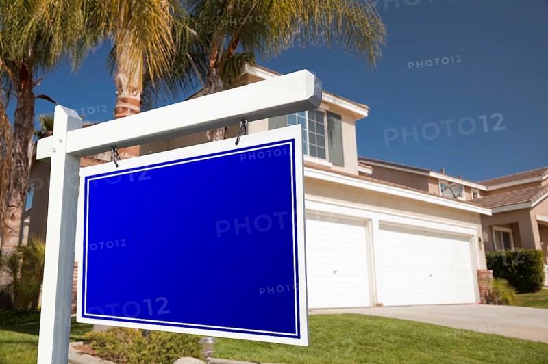 Blank real estate sign in front of house