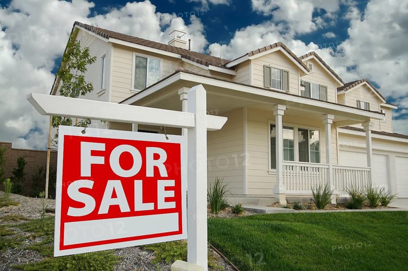 Home for sale sign in front of beautiful new home