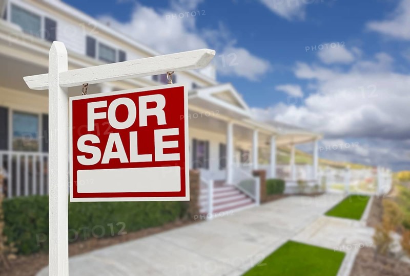 Home for sale real estate sign and beautiful new house