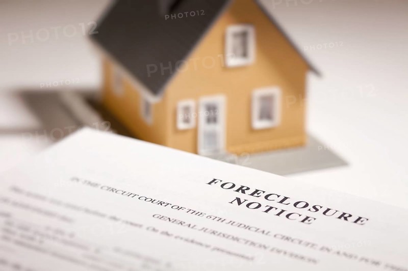 Foreclosure notice and model home on gradated background with selective focus