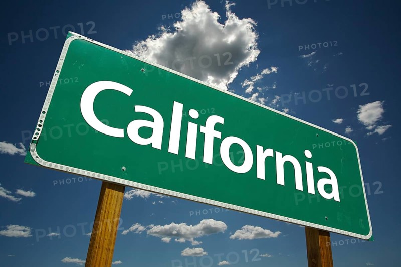 Green california road sign with dramatic clouds and sky