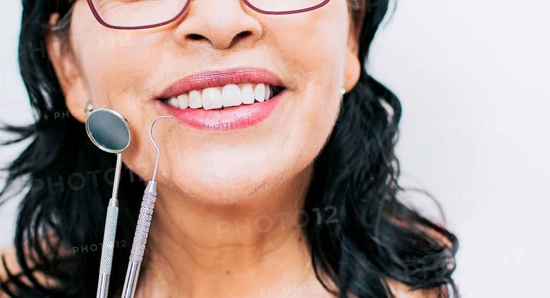 Close up of perfect smile and dentist tools on white background
