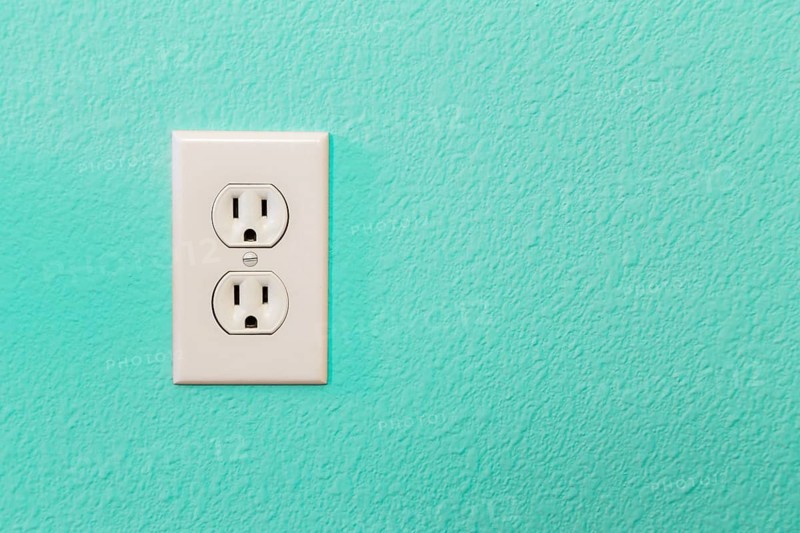 Electrical sockets in colorful bright teal wall of house