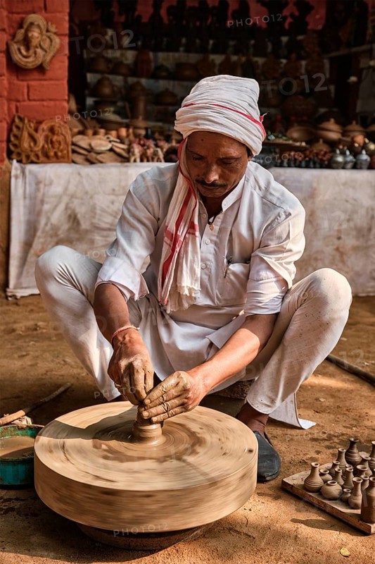 Indian potter at work: throwing the potter's wheel and shaping ceramic vessel and clay ware: pot
