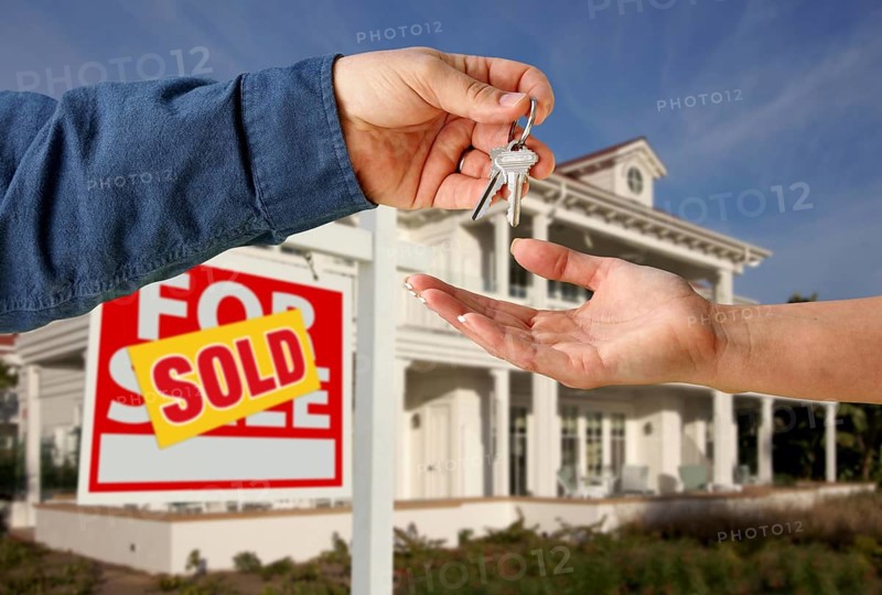 Handing over the house keys in front of a beautiful new home