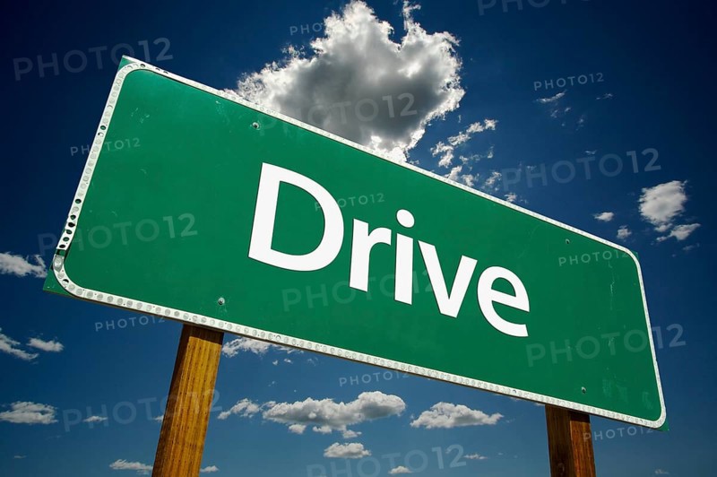 Drive green road sign with dramatic clouds and sky