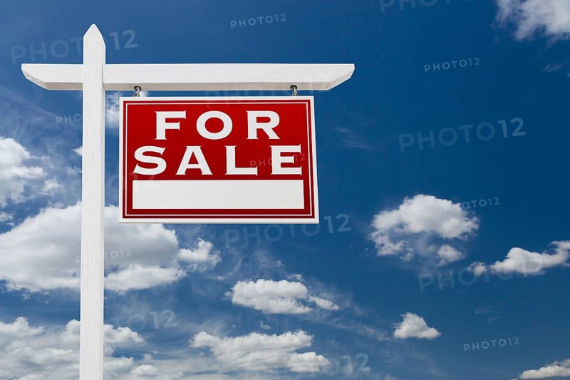 Right facing for sale real estate sign over blue sky and clouds with room for your text